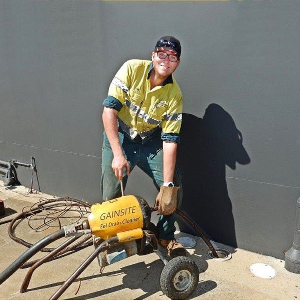 plumber with drain cleaning machine