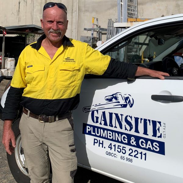 licenced plumber and gas fitter standing next to ute